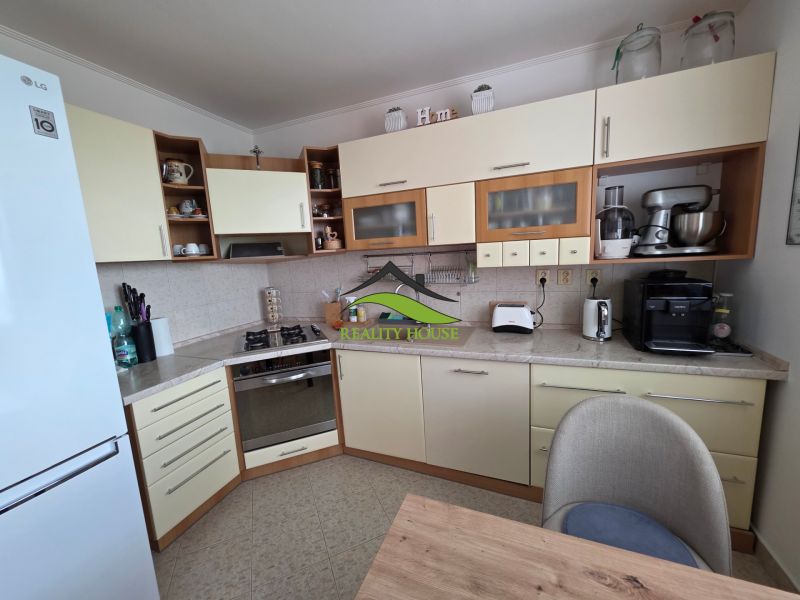 A kitchen in a 3-room apartment with modern appliances and wooden cabinets.