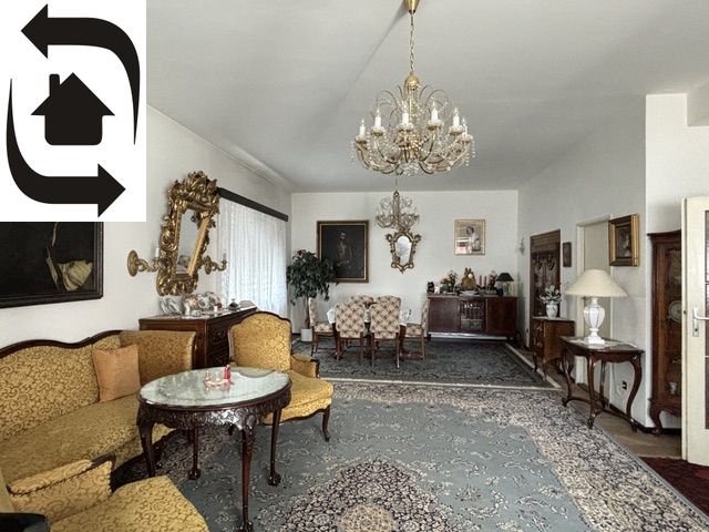 Interior of a villa with historical furniture, carpet, chandelier, and paintings in a classical style.