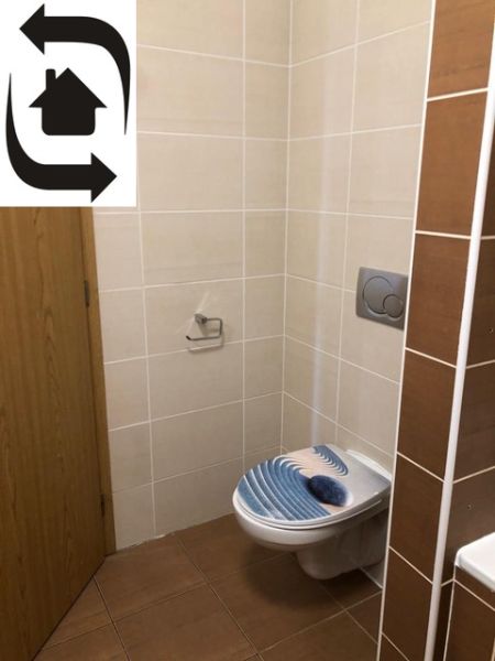 Bathroom with toilet in a 2-room apartment, tiles and a toilet bowl with a colored seat.