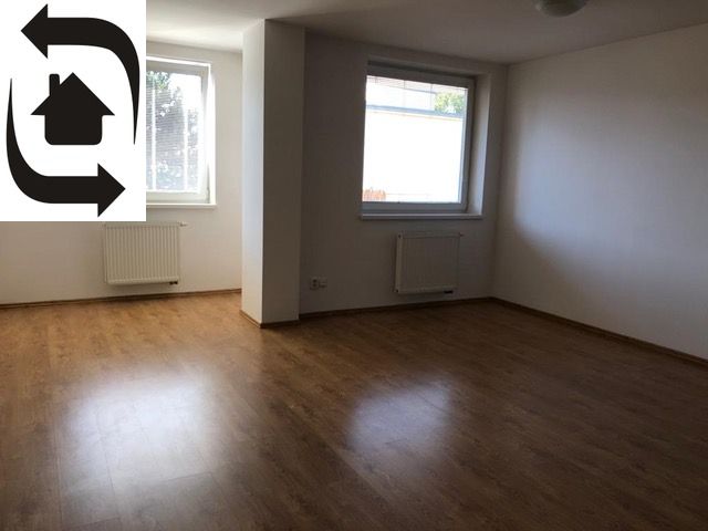 A spacious room in a 2-room apartment with a wooden decor floor.