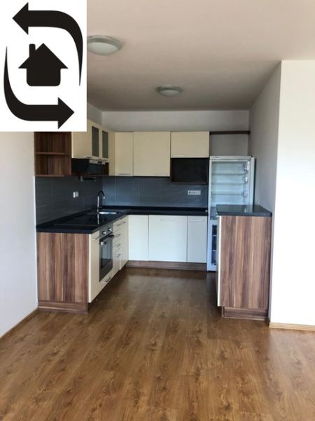 A kitchen with dark wood decor and appliances in a 2-room apartment.