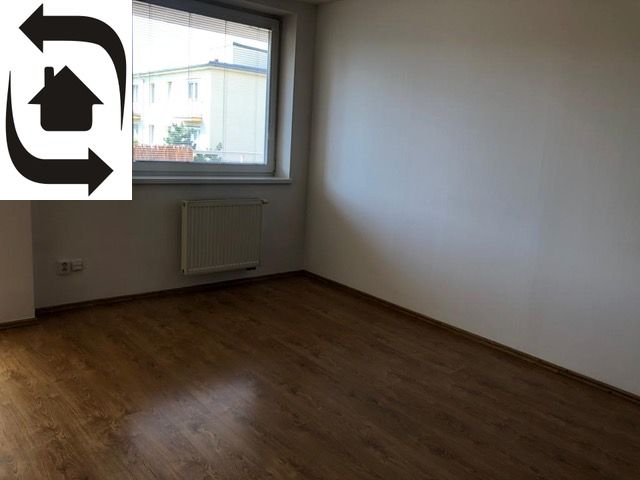 An empty room with a wooden decor floor in a 2-room apartment.