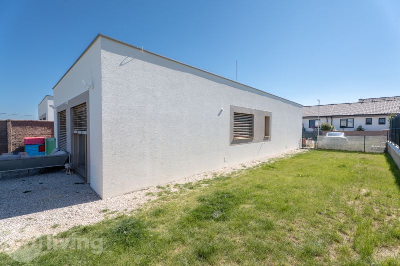 A family house in Trenčianske Jastrabie with a white facade and a manicured lawn.