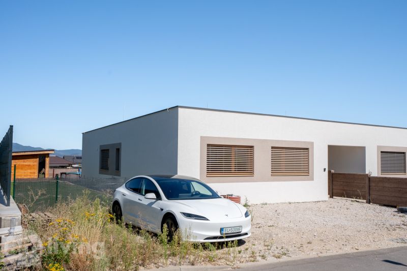 A family house in Trenčianske Jastrabie with a white vehicle on a gravel property.
