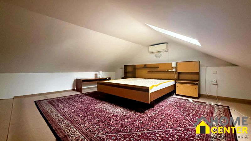 Attic room with a bed, carpet, and air conditioning in a cottage.