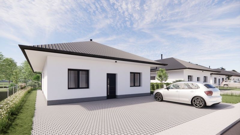A family house in Prašník with a white facade, gray roof, and adjacent parking lot.