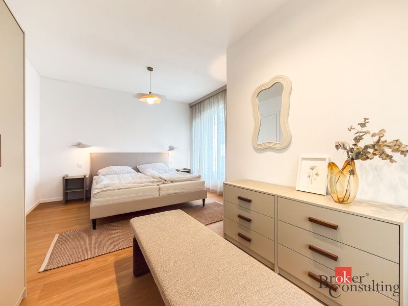 Bedroom in a 4-room apartment with a wooden decor floor and a large bed.