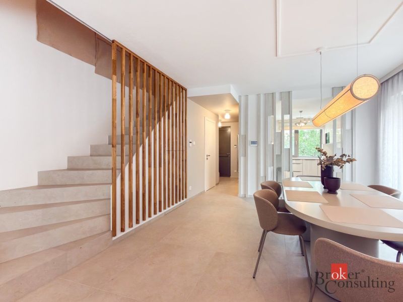 Dining room and stairs in a 4-room apartment with minimalist furniture and decoration.
