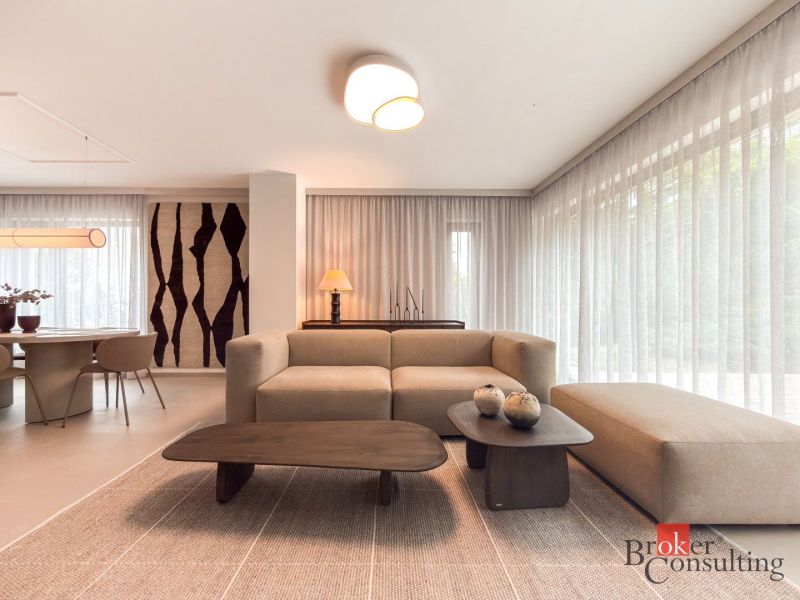 Living room in a 4-room apartment with a wooden decor floor, light furniture, and decorations.