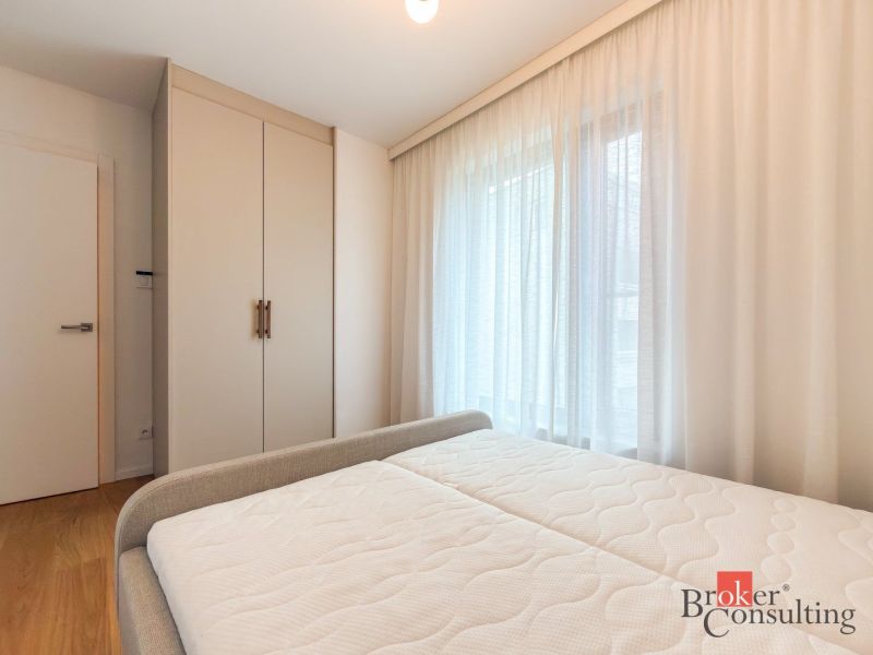 Bedroom in a 4-room apartment with a wardrobe, bed, and wooden decor flooring.