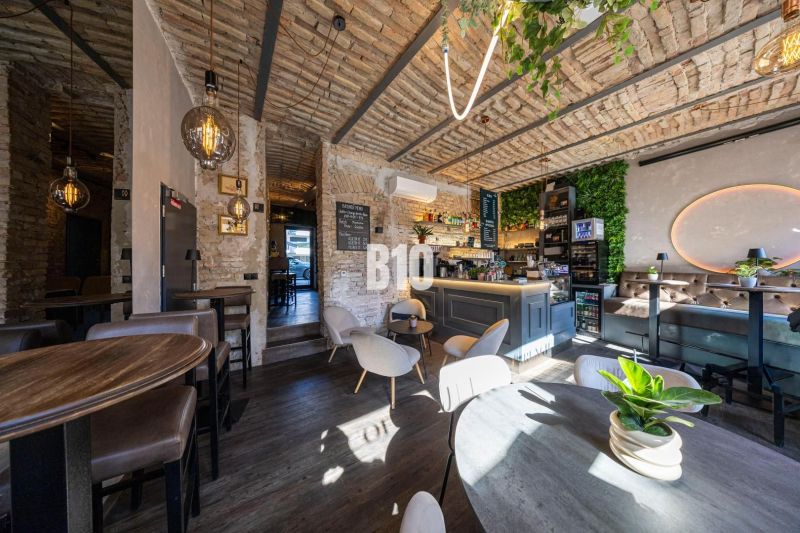 Interior of a gastro space with brick walls, wooden decor, and modern lighting.
