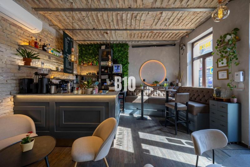 Interior of a gastro space with brick walls, a bar, and a wooden decor floor.