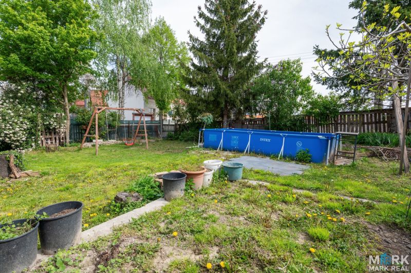 A garden with a swimming pool and a swing on a residential plot in Dunajská Lužná, Kováčska.