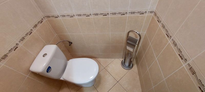 Bathroom with toilet and ceramic tiles in a 3-room apartment.