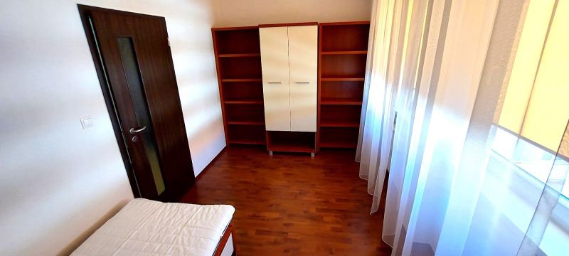 Bedroom in a 3-room apartment with a wooden decor floor and cabinets.