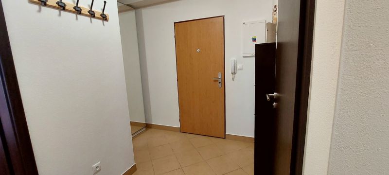 Entrance hall in a 3-room apartment with a coat rack and tiled floor.