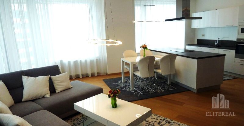 Living room in a 3-room apartment with a spacious kitchen and a wooden decor floor.
