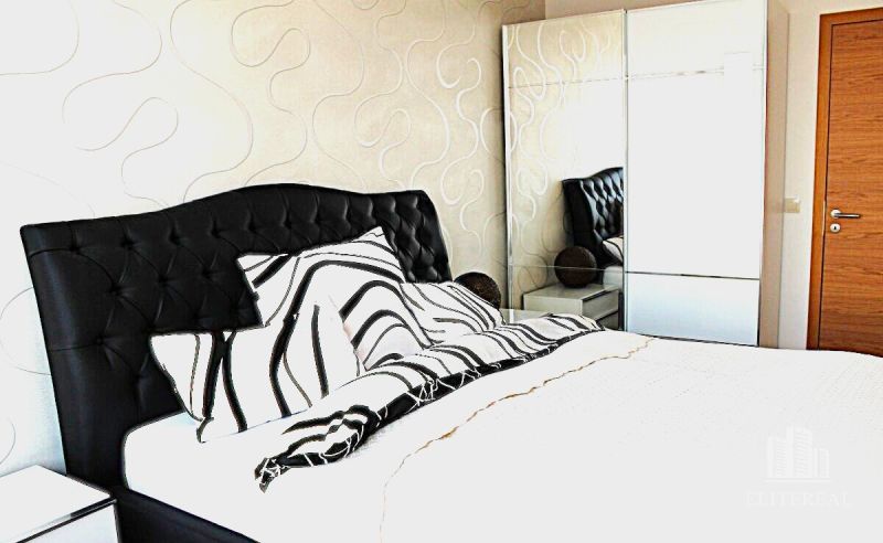 Bedroom in a 3-room apartment with a black headboard and a mirrored wardrobe.