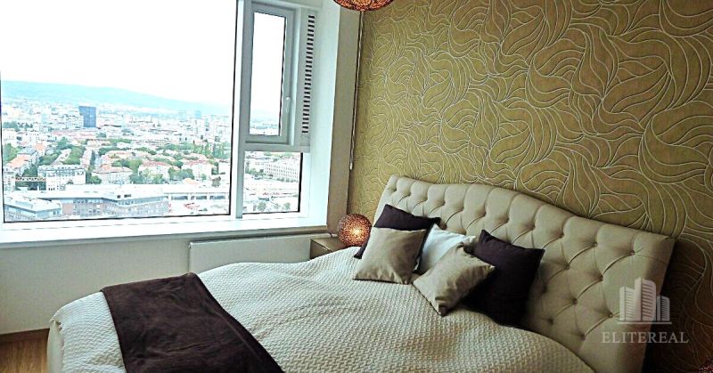 Bedroom in a 3-room apartment with a wallpapered wall, view, and bed.