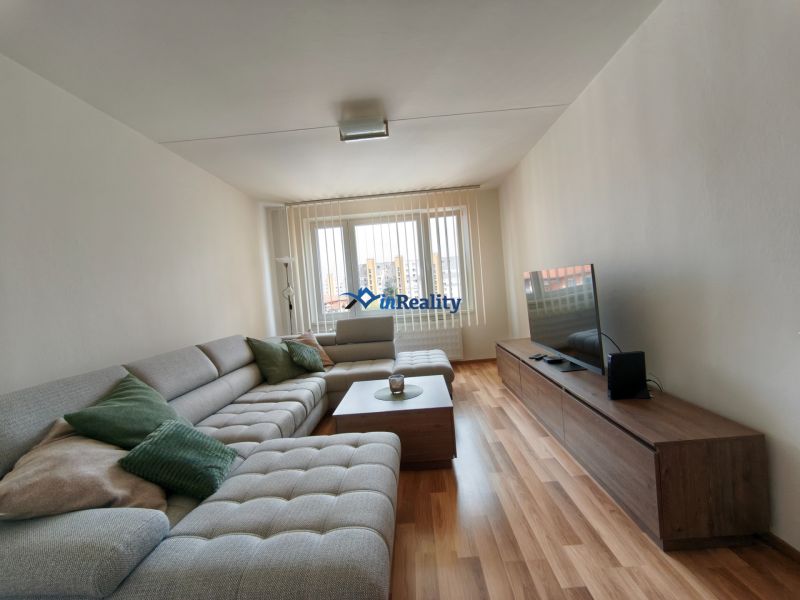 Living room in a 3-room apartment with a sofa and a wooden decor floor.