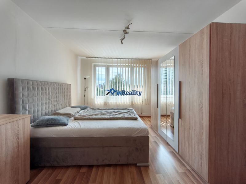 A bedroom in a 3-room apartment with a comfortable bed and a floor with a wooden decor.