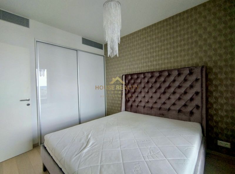 Bedroom in a 2-room apartment with a bed and built-in wardrobe, elegant wallpaper.
