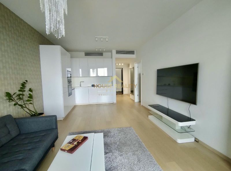 Living room with kitchen, TV on the wall, wooden decor flooring, 2-room apartment.