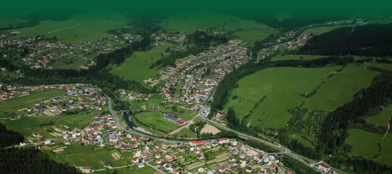 Aerial view of agricultural and forest land in Olešná with buildings and roads.