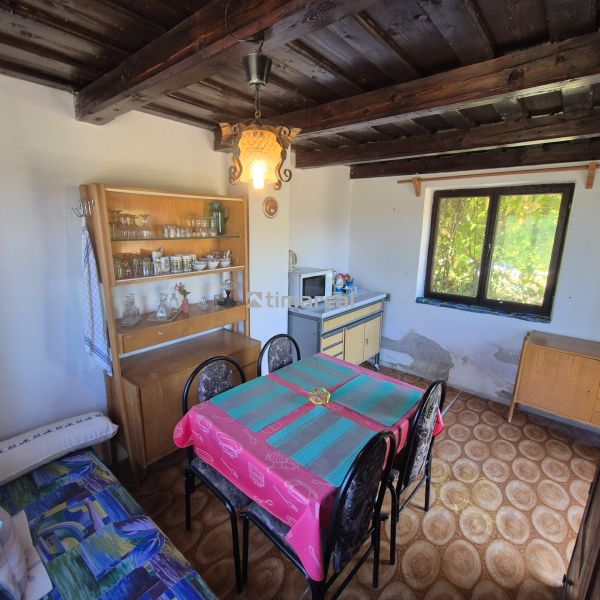 A dining room in a cabin with a wooden decor floor and rustic furnishings.