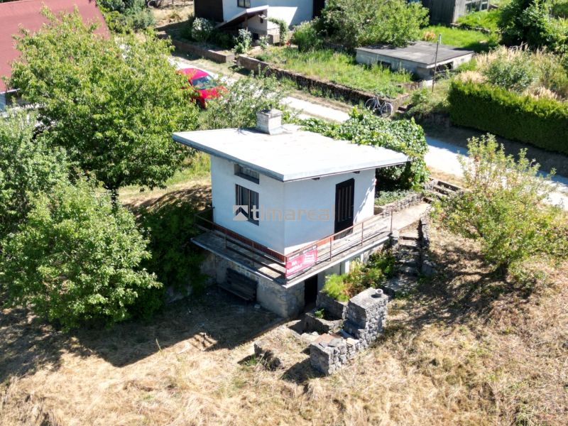 A cottage in Myjava surrounded by greenery with an access road and parking lot.