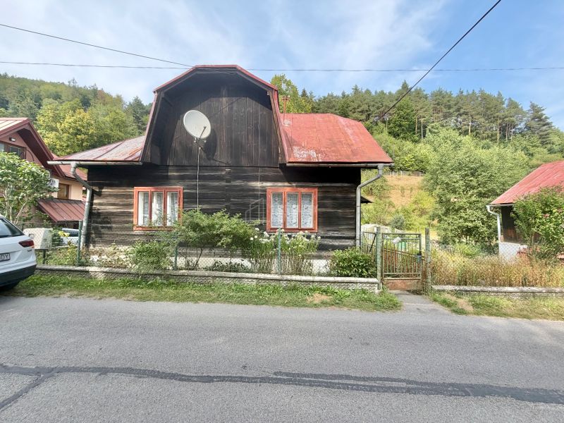 A family house in the village of Ochodnica on Ochodnica Street, with a wooden facade and a red roof.