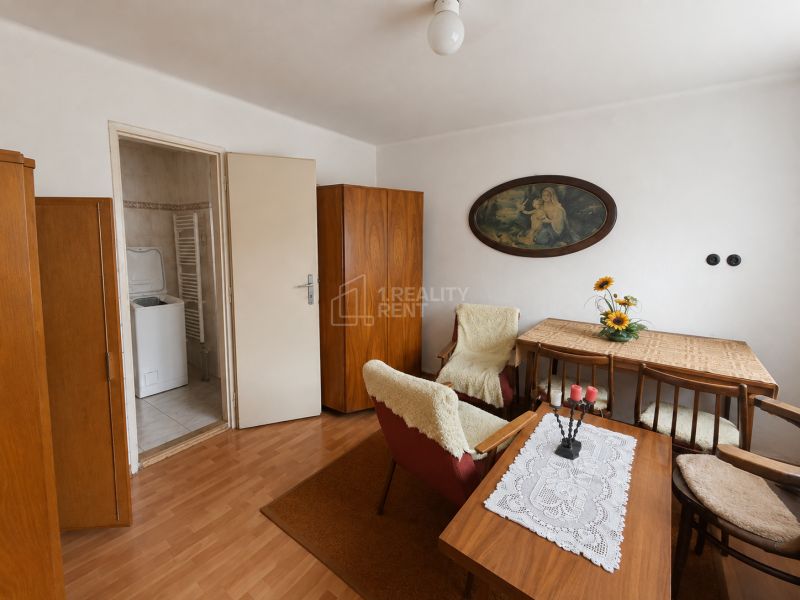 Interior of a family house with wooden decor, a dining table, and open doors to the laundry room.