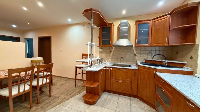 A kitchen with wooden decor and a dining table in a 3-room apartment.