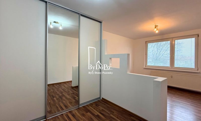 Interior of a 3-room apartment with a wooden decor floor and a built-in wardrobe.