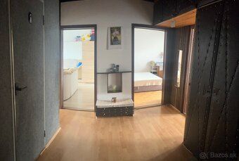 Interior of a 3-room apartment with a wooden decor floor and entrance to the living room and bedroom.