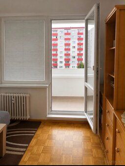 A room in a 3-room apartment with a wood-decor floor and a balcony.