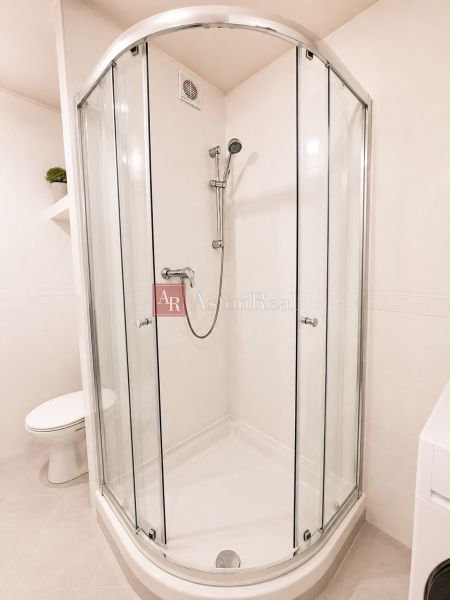 Shower corner with toilet and washing machine in a 2-room apartment.