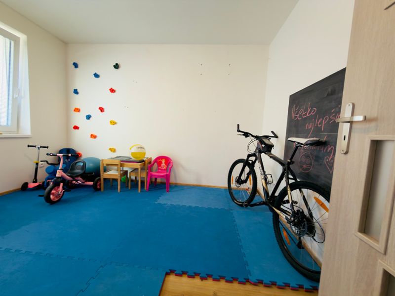 A children's room with toys, a bicycle, and a drawing board in a family house.