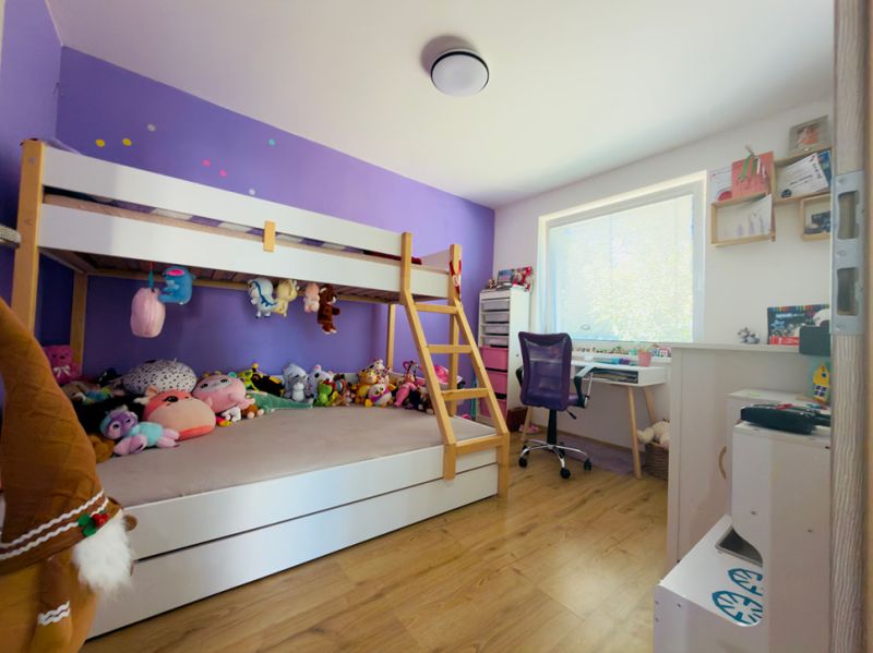 Children's room with a bunk bed and a wooden decor floor in a family house.