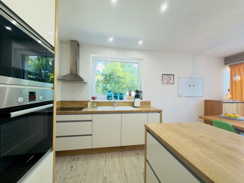 A kitchen with a wood-patterned floor in a family house, bright and spacious.