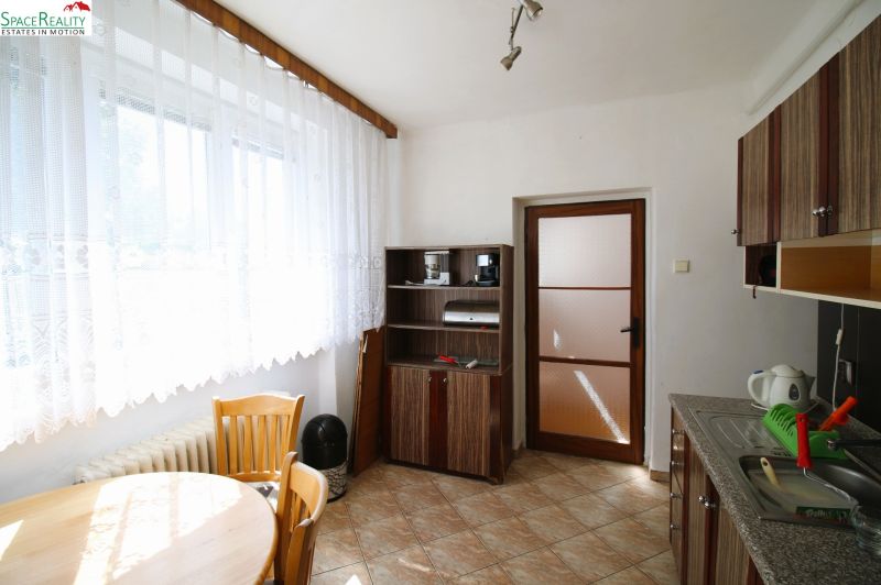 A kitchen with a table and chairs in a 3-room apartment, floor with wooden decor.