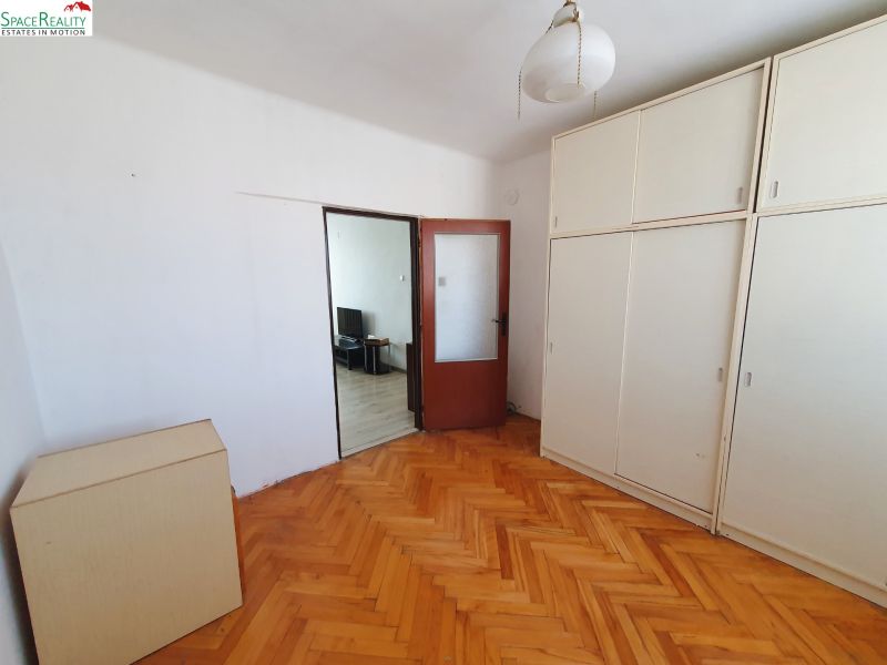 A room in a 3-room apartment with a wooden decor floor and a built-in wardrobe.