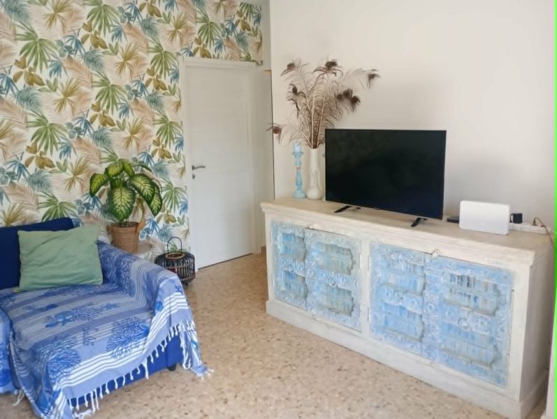 Recreational apartment with a television, a colorful wall, and a comfortable armchair.