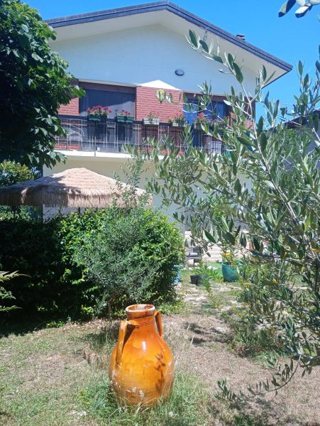 A garden at a holiday apartment in Bibione with a large decorative container.