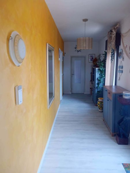 The hallway of a recreational apartment with a wooden decor floor and a yellow wall.