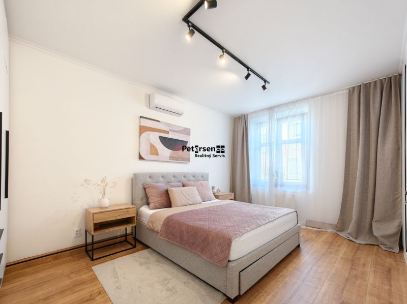 A bedroom in a 3-room apartment with a comfortable bed and a floor with a wooden decor.