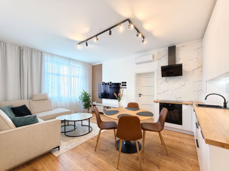 Living room in a 3-room apartment with a wooden decor floor and a light-colored sofa.