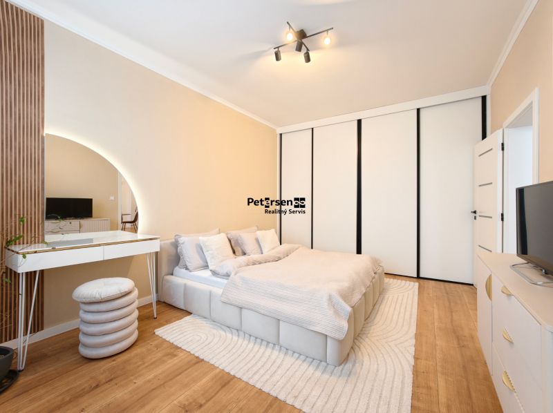 A bedroom in a 3-room apartment with white furniture and a wooden decor floor.