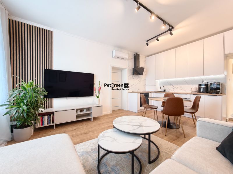 Living room in a three-room apartment with a wooden decor floor and modern furnishings.