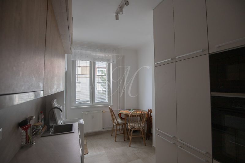 Kitchen of a one-room apartment with a dining area and modern cabinets.